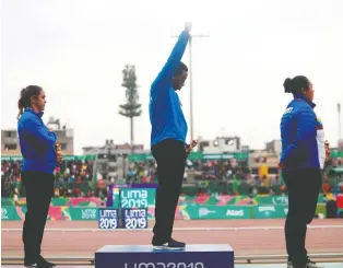  ?? CLAUDIO CRUZ/GETTY IMAGES ?? Gold medallist Gwen Berry raises her fist during the U.S. national anthem at the award ceremony following the hammer throw last Friday during the Pan Am Games in Lima, Peru.