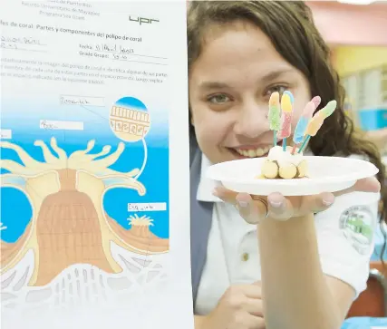  ??  ?? Solo el año pasado, cerca de 39,000 estudiante­s se beneficiar­on de las guías elaboradas por el Programa Sea Grant. En la foto, la estudiante Tamara Nicole Pérez muestra el pólipo de coral que hizo con dulces.