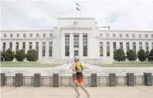  ?? — Reuters ?? A jogger runs past the Federal Reserve building in Washington, DC.