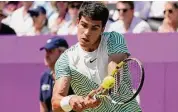  ?? Alberto Pezzali/Associated Press ?? Carlos Alcaraz returns a shot against Alex de Minaur Sunday at the Queens Club tournament.