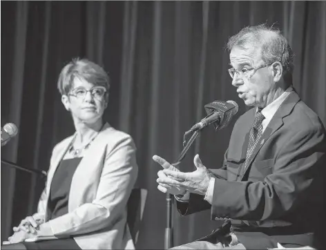  ?? BRIAN MCINNIS/SPECIAL TO THE GUARDIAN ?? Mayoral candidate Kim Devine listens as Philip Brown makes a point during the Charlottet­own Mayoral Debate Wednesday evening at UPEI.