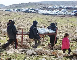  ?? AP PHOTO ?? Iraqis from the Yazidi minority carry a bed frame on Mount Sinjar in northern Iraq.