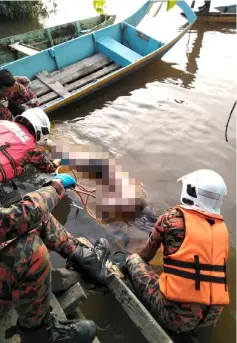  ??  ?? Bomba personnel retrieve the body from the river.