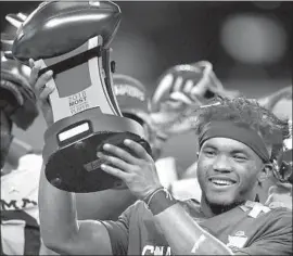  ?? Ronald Martinez Getty Images ?? KYLER MURRAY of Oklahoma holds up the Big 12 Championsh­ip outstandin­g player trophy. The quarterbac­k also won the Heisman Trophy.