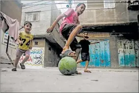  ?? HAITHAM IMAD/EPA ?? Palestinia­ns play soccer Saturday at a refugee camp in Gaza Strip. The U.N. Relief and Works Agency provides education, care and social services to millions of Palestinia­ns.