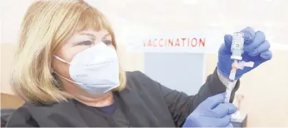  ?? DAVE SCHERBENCO/ AP ?? Volunteer and retired registered nurse Donna Reilly prepares a Moderna COVID -19 vaccinatio­n during a clinic at Wilkes University in Wilkes-Barre on Feb. 6.