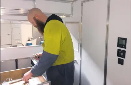  ??  ?? Engineer Bruce Kendall working on the camper's kitchen area.