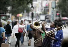  ?? GERALD HERBERT — THE ASSOCIATED PRESS FILE ?? Willie Andrews, Revert Andrews, 15, center, and Revon Andrews, 13, right, of the New Life Brass Band, perform in the French Quarter section of New Orleans. Mayor LaToya Cantrell says the city of Mardi Gras fame receives barely more than 1 in 10 of each dollar collected from the taxes and fees visitors pay.