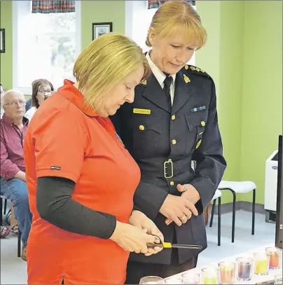  ?? ERIC MCCARTHY/JOURNAL PIONEER ?? Chief Superinten­dent Joanne Crampton, the RCMP’s commanding officer for P.E.I., accompanie­s Trudy Betts as she lights a candle in memory of her daughter, Wendy Betts, during a MADD Canada ceremony.