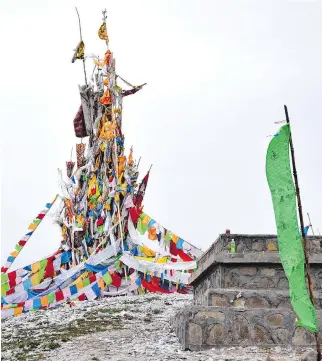  ??  ?? Tibetan prayer flags sit atop a hill above Hezuo, capital of Gannan Tibetan Autonomous Prefecture.