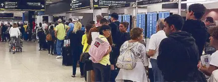  ?? AFP ?? Passengers flying from Miami Internatio­nal Airport wait in line to enter the checkpoint at Concourse F, where some of the flights of a closed terminal were diverted, in Florida on Sunday. Operations at Concourse G were shut down during the weekend due to a shortage of security agents sparked by the partial US government shutdown.