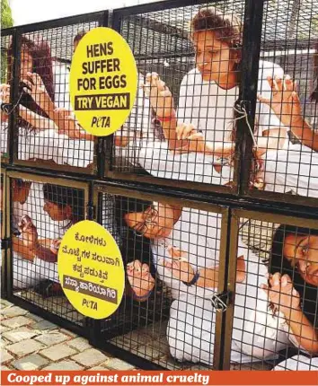  ?? PTI ?? ■ Peta India activists sit inside a cage during a demonstrat­ion against animal cruelty in Bengaluru, Karnataka, yesterday. Although the charity sometimes faces criticism for its style of advocacy — which often includes nudity and shocking stunts — it...