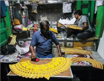  ?? ?? Artisans prepare decoration­s for idols of Hindu goddess Durga on Sept. 19 ahead of Durga Puja festival.