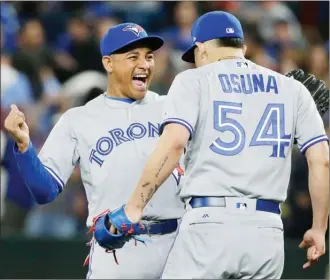  ?? The Associated Press ?? Toronto Blue Jays left fielder Ezequiel Carrera, left, celebrates with closing pitcher Roberto Osuna after the Blue Jays defeated the Seattle Mariners 4-2 in a baseball game on Saturday in Seattle. Carrera had a solo home run and Osuna earned the save...