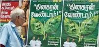  ?? PTI ?? A man looking at a poster of a magazine displaying the picture of K Palaniswam­i and his rival leader O Panneersel­vam on the two leaves depicting party symbol in Chennai . —