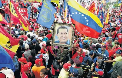  ?? Picture: REUTERS ?? GRIM CHAPTER: The spectre of the late Hugo Chavez looks out over a protest in Caracas, Venezuela, this week