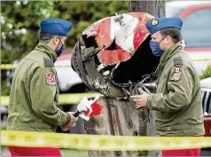  ?? JONATHAN HAYWARD / THE CANADIAN PRESS VIA AP ?? Canadian Forces Snowbird captains Joel Wilson (left) and Erik Temple check out the crash scene where a Snowbird jet slammed into a Kamloops, British Columbia, neighborho­od on Sunday.