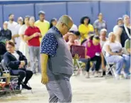  ?? ?? Héctor ‘El Father’ empuña La Biblia para predicarle a un grupo de personas en su isla.