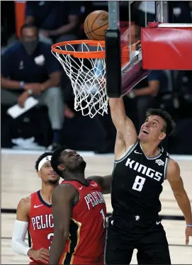  ?? ASHLEY LANDIS-POOL/GETTY IMAGES ?? Bogdan Bogdanovic (8) of the Sacramento Kings goes up for a basket against Zion Williamson (1) and Josh Hart (3) of the New Orleans Pelicans on August 6 in Lake Buena Vista, Fla.