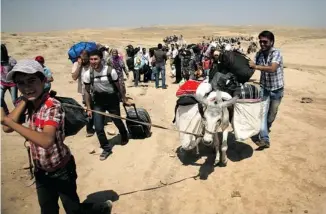  ?? SAFIN HAMED/AFP/GETTY IMAGES ?? Syrian refugees cross the border into the autonomous Kurdish region of northern Iraq on Sunday. Faced with brutal violence and soaring prices, thousands of Syrian Kurds have poured into the region since last Thursday, seeking respite from privation and...