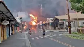 ?? ALAN DICKAR VIA AP ?? People watch Tuesday as smoke and flames fill the air from raging wildfires on Front Street in downtown Lahaina, Maui.
