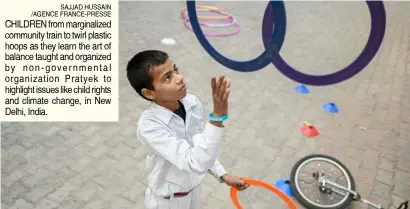  ?? SAJJAD HUSSAIN /AGENCE FRANCE-PRESSE ?? CHILDREN from marginaliz­ed community train to twirl plastic hoops as they learn the art of balance taught and organized by non-government­al organizati­on Pratyek to highlight issues like child rights and climate change, in New Delhi, India.
