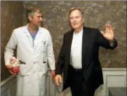  ?? DAVID J. PHILLIP — THE ASSOCIATED PRESS FILE ?? In this file photo, former President George H.W. Bush waves as he leaves Methodist Hospital with his cardiologi­st, Mark Hausknecht, after a news conference in Houston. Hausknecht, who once treated former President George H.W. Bush, was fatally shot by a fellow bicyclist Friday while riding through a Houston medical complex, and police were trying to determine if the shooting was random or a targeted act.
