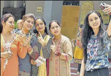  ?? BIRBAL SHARMA/HT ?? Girls taking selfie outside a polling station in Mandi.