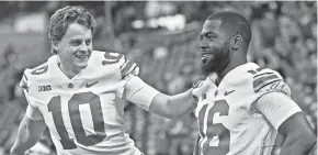  ?? BARBARA J. PERENIC/COLUMBUS DISPATCH ?? Ohio State quarterbac­ks Joe Burrow (10) and J.T. Barrett warm up before the Big Ten Championsh­ip game on Dec. 2, 2017.