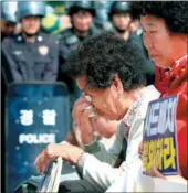  ?? YONHAP NEWS AGENCY ?? A protester weeps as US military vehicles carry components of the THAAD system on Thursday in Seongju.