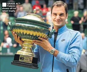  ??  ?? GRASS ACT: Federer shows off his latest trophy