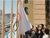  ?? THIBAULT CAMUS/AP ?? Mayor of Marseille Benoit Payan, center, raises the Olympic flag with Paris 2024 president Tony Estanguet, center right, Friday in southern France.