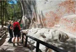  ??  ?? Descending through spotted gums to Carnarvon Creek (top), the path is steep but well maintained. Michelle Whitehouse of Australian Nature Guides (above, at right) explains the spiritual significan­ce of the paintings in the Art Gallery to writer Hannah...