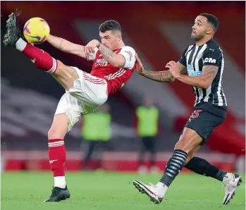  ?? — AFP ?? Granit Xhaka (left) of Arsenal clears the ball from the path of Newcastle United’s Callum Wilson during their English Premier League match at the Emirates Stadium in London on Monday. Arsenal won 3-0.