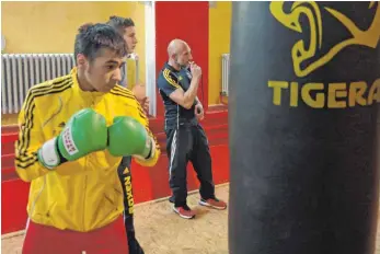  ?? FOTO: JOCHEN DEDELEIT ?? Akif Akgöz bei der Arbeit am Boxsack, im Hintergrun­d Trainer Giovanni Saravo.