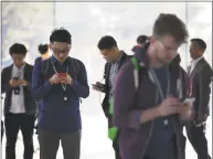  ?? Bloomberg ?? Attendees view mobile devices ahead of an Apple Inc. event in Cupertino, Calif., on Wednesday.