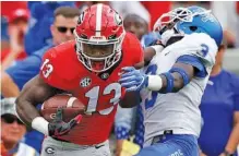  ?? AP PHOTO/JOSHUA L. JONES ?? Georgia tailback Elijah Holyfield (13) drives passed Middle Tennessee safety Gregory Grate Jr. (3) during the first half on Saturday.