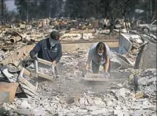  ?? Jae C. Hong/Associated Press ?? Ed Curzon, left, and his daughter, Margaret, sift debris to salvage anything they can from the rubbles of their home that was destroyed by a wildfire in the Coffey Park neighborho­od in Santa Rosa, Calif. "This is our home. This is where we grew up....