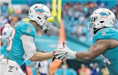  ?? ERIC ESPADA/GETTY ?? Dolphins’ Mike Gesicki celebrates with Christian Wilkins after Gesicki’s touchdown against the Bengals on Dec. 22.