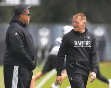  ?? Paul Chinn / The Chronicle ?? Raiders general manager Reggie McKenzie (left) chats with Todd Downing, who’s in his first year as offensive coordinato­r.