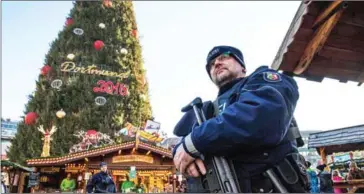  ?? BERND THISSEN/AFP ?? Police officers patrol yesterday at a Christmas market in Dortmund, western Germany, as security was ramped up after a deadly rampage by a lorry driver at a Berlin Christmas market.