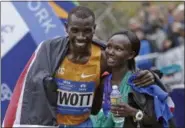  ?? KATHY WILLENS — AP FILE ?? Stanley Biwott, left, embraces fellow Kenyan Mary Keitany after the pair won the men’s and women’s divisions of lasy year’s New York City Marathon. About 50,000 people from more than 120 countries are running in the 40th anniversar­y of the race,...