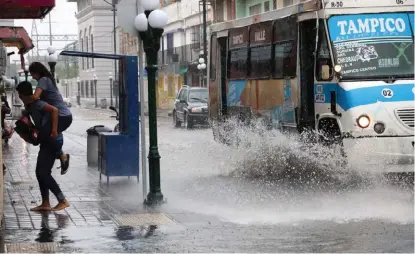  ?? JOSÉ LUIS TAPIA ?? La lluvia dejó encharcami­entos y la gente evitó a toda costa mojarse.