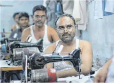  ?? FOTO: DPA ?? Näher im Slum Dharavi in Mumbai: Das Textilbünd­nis soll die Bedingunge­n von Zulieferer­n von Bekleidung verbessern.