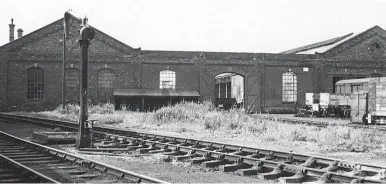  ?? Authors’ Collection ?? Four months after the shed made the news through its nocturnal runaway from the coaling stage and onwards out of view to the left, on Tuesday, 15 August 1961 we see what was the 1881 roundhouse, from the south end when it was in use as a wagon shop. Note, on the far right, an entrance made to help adapt the building for rolling stock repairs. After closure to locomotive­s and the passing over of the site to wagon repairs, the big loss was the roof, and it is of note that only the broadest of the three gables, the central one, is lost, so there was still a reasonable amount of cover beneath the two narrower sections on either side. The post-1933 doorway on the right would in time be mirrored by a new doorway on the left, but not until all railway use had ended.