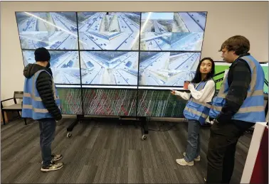  ?? MARK HUMPHREY — THE ASSOCIATED PRESS ?? Researcher­s look at live interstate traffic images and data screens in Nashville, Tenn. Researcher­s say they have successful­ly used artificial intelligen­ce in a group of wirelessly connected cars to help ease rush hour traffic on an interstate in Nashville. The aim is to reduce phantom traffic jams — the start-and-stop congestion on crowded roads that has no obvious cause.
