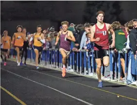  ?? PHOTOS BY JOE TIMMERMAN/INDYSTAR ?? Martinsvil­le’s Martin Barco leads the pack in the Miracle Mile race during the Flashes Showcase on Friday at Franklin Central High School. Barco finished in first place with a time of 4:11.53.