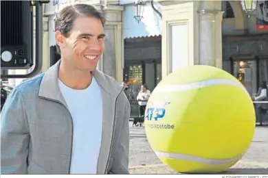  ?? ALESSANDRO DI MARCO / EFE ?? Rafael Nadal se pasea por las calles de Turín delante de una pelota de tenis gigante de promoción del torneo.