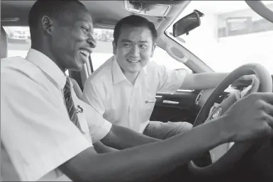  ?? PROVIDED TO CHINA DAILY ?? A potential Kenyan buyer takes driver’s seat to test-drive BAIC’s new truck model under the guidance of a Chinese salesperso­n in Nairobi,