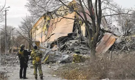  ?? ANDRIY ANDRIYENKO AP ?? Police officers check a school that was damaged in Russian shelling in Kramatorsk, Ukraine, Thursday as fighting continued.